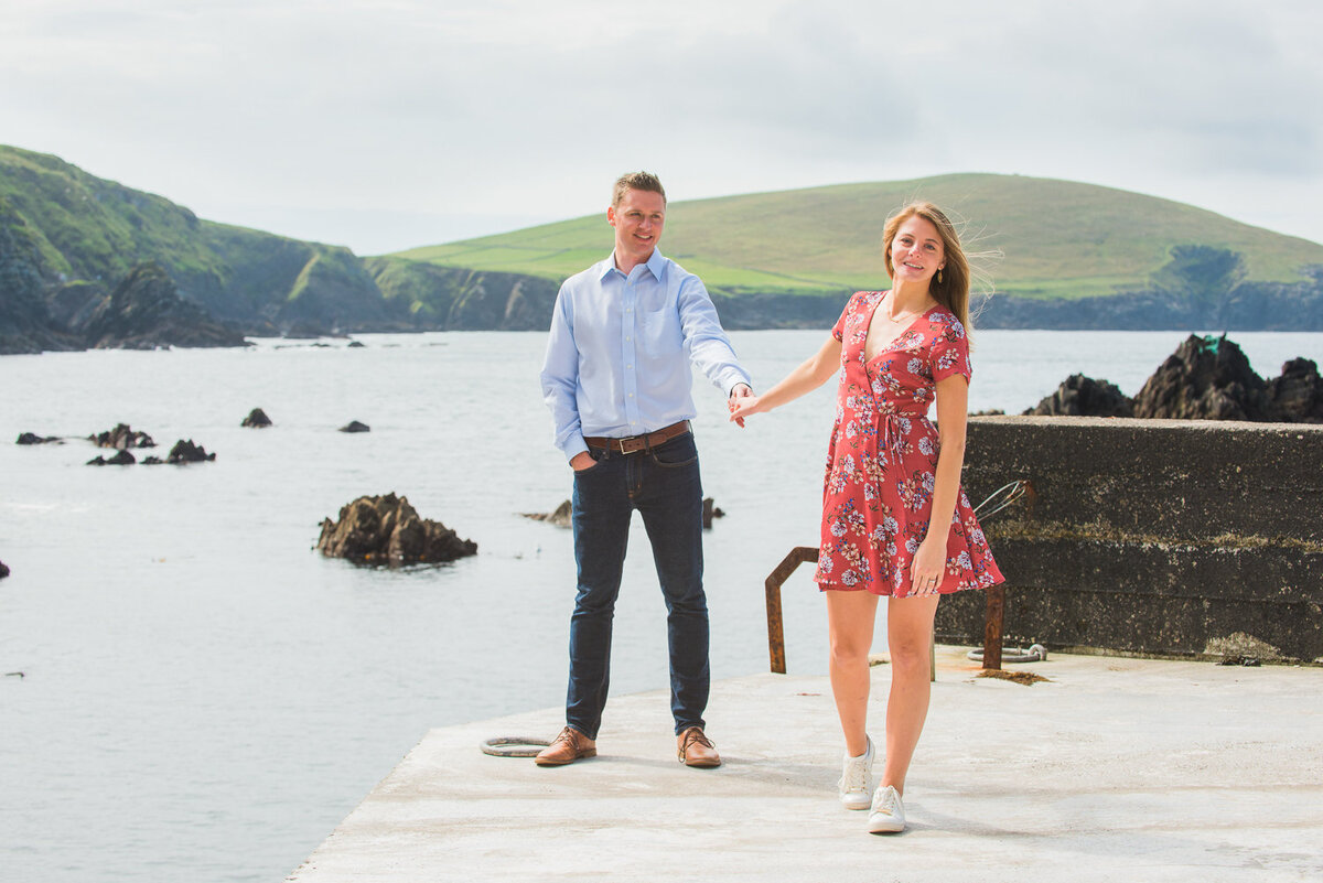 male and female couple in summer clothes, holding hands, standing on a pier in Kerry