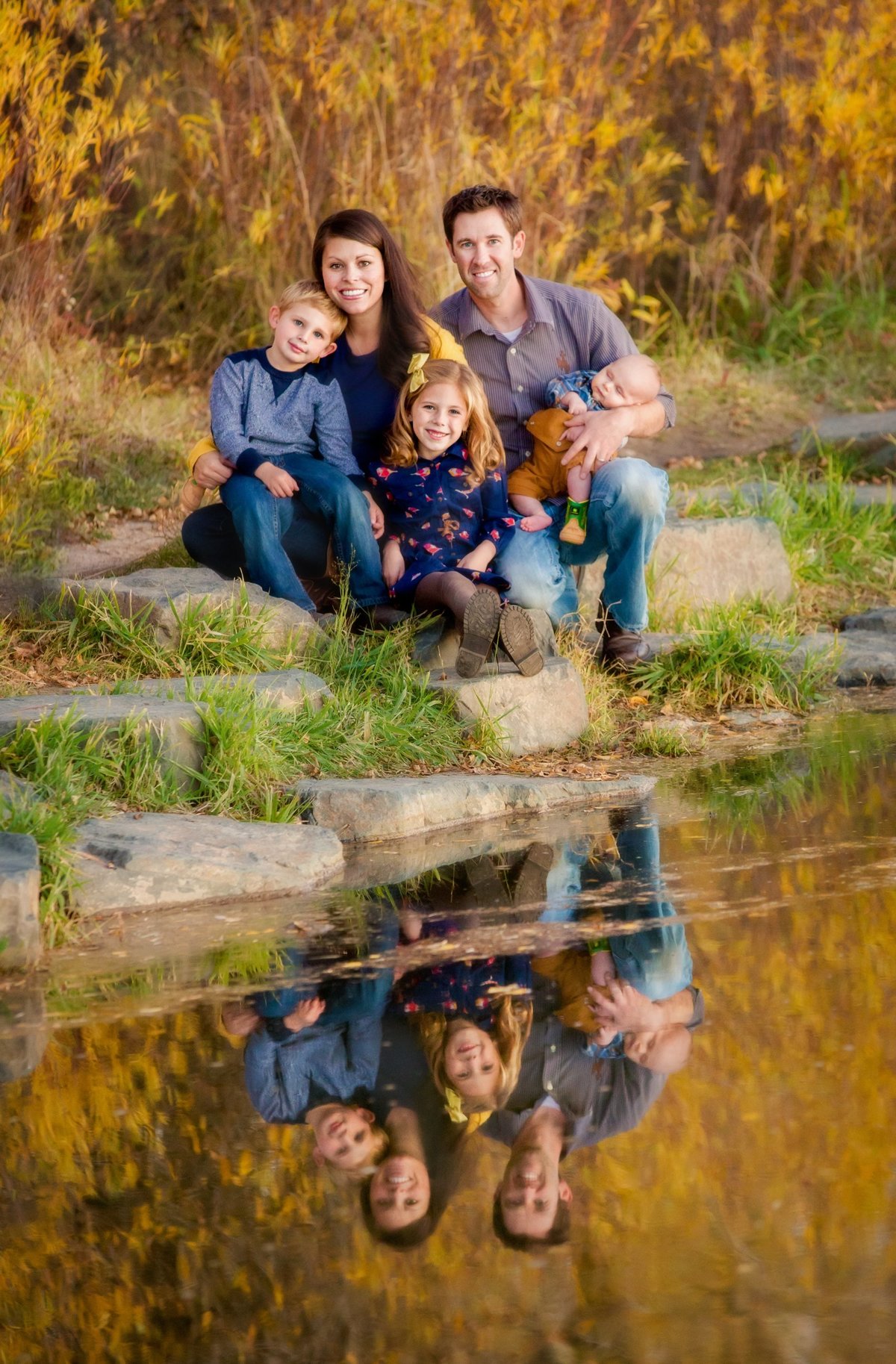 A reflection picture of a family sitting together next to the Laramie River in the fall.