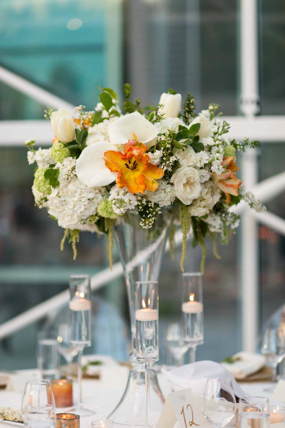 Lovely tall flower arrangements with what callas and pops of orange!