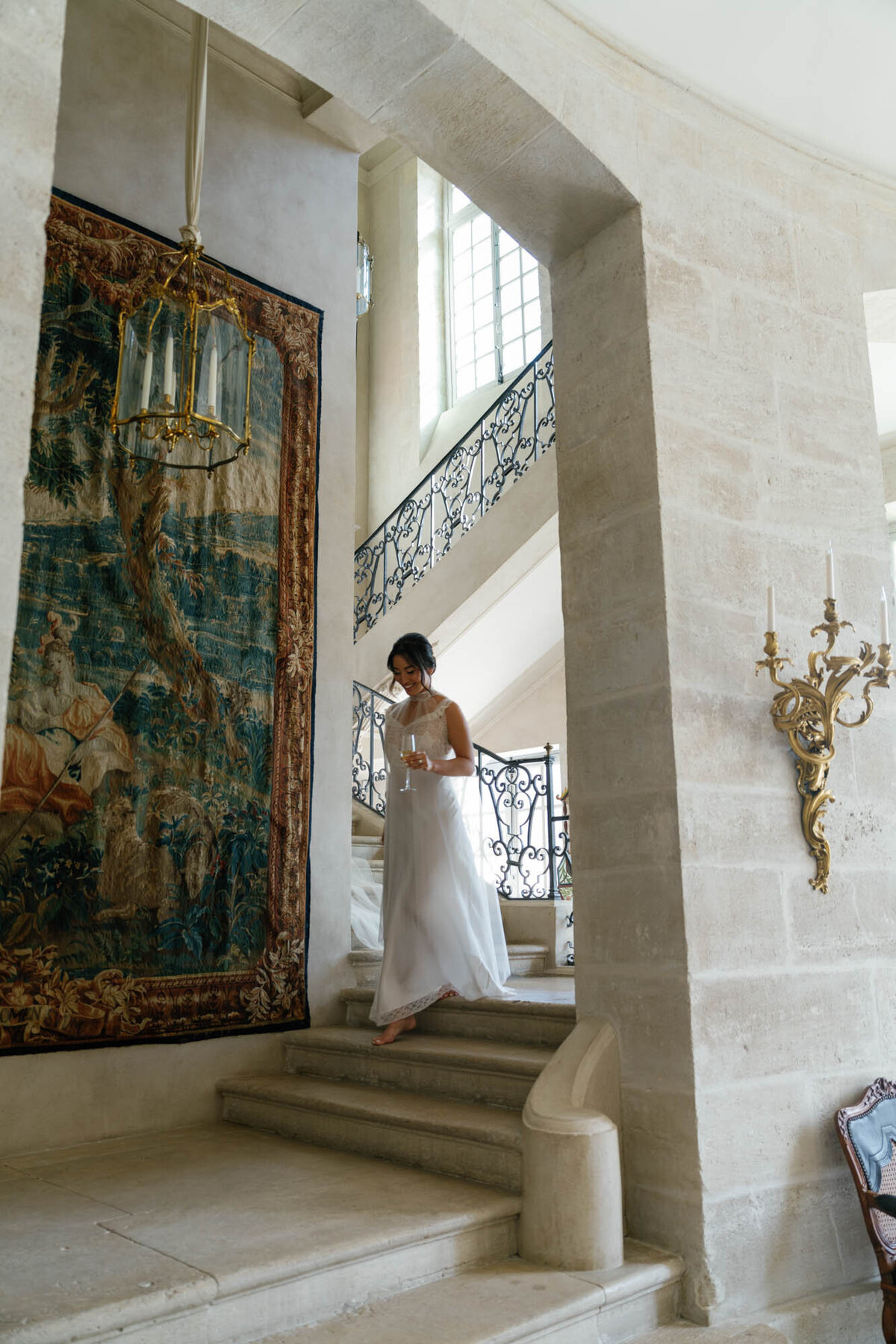 a bride walking in the stair of chateau de Villette