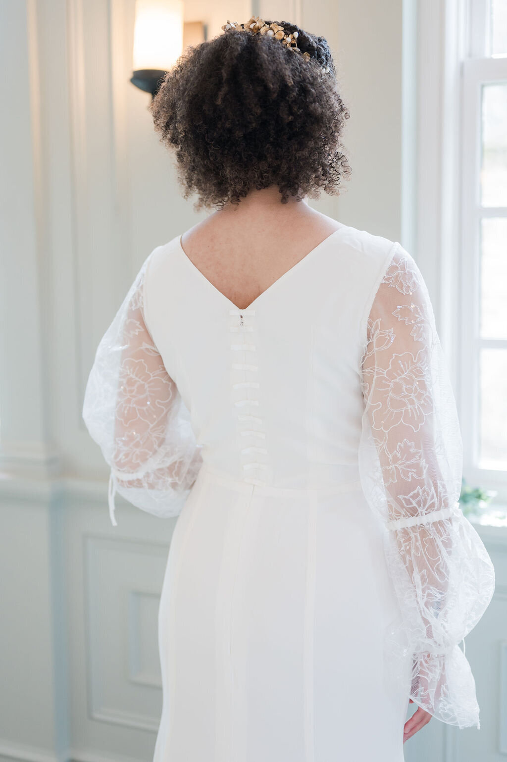 Harlow is a more modest wedding dress style with its high v-back, which is accented with a column of bows down to the waist.
