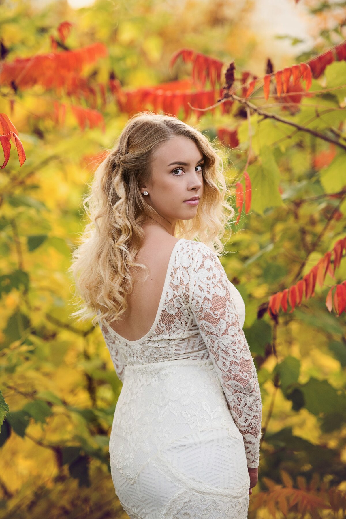 Mahtomedi high school senior photo of girl in white prom dress in fall leaves