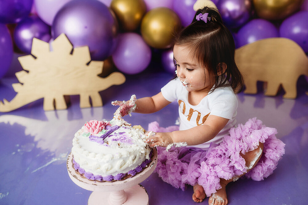 Baby digs into her birthday cake during her Cake Smash Birthday Portrait Session in Asheville, NC.