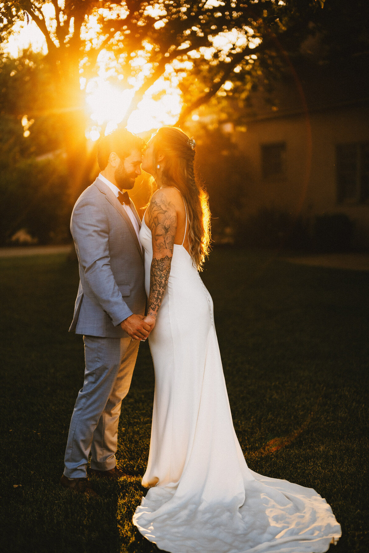 Romantic_sunset_portrait_of_bride_kissing_groom_forehead