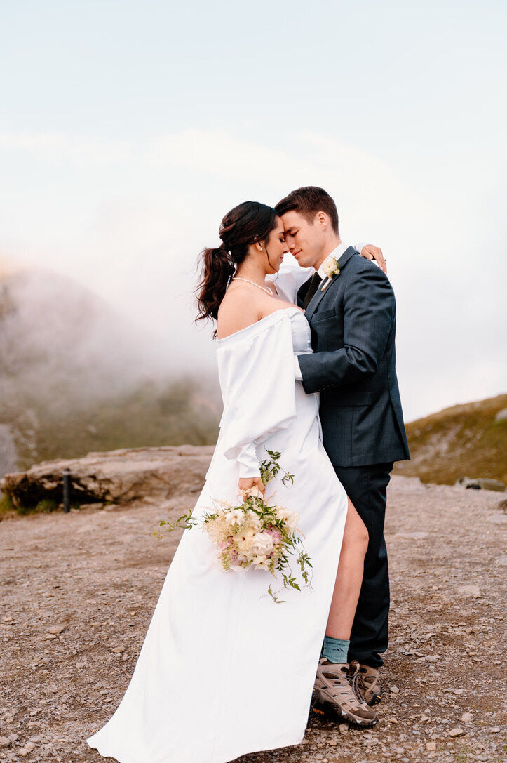 Bride and groom in their hiking boots on top of a mountain