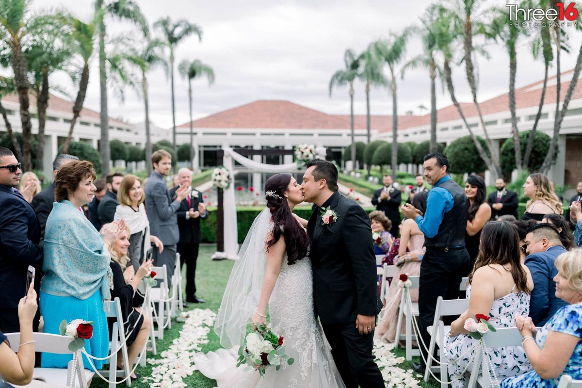 Bride and Groom stop on the aisle for a second kiss