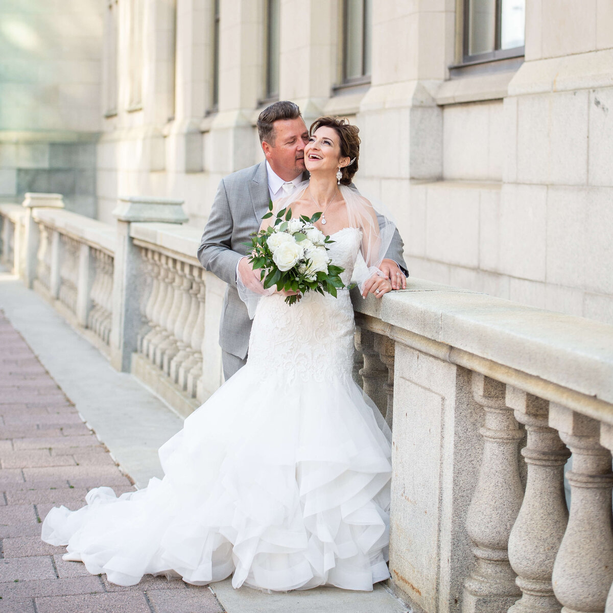 Ottawa wedding photography of a bride and groom laughing and hugging outside the Chateau Laurier