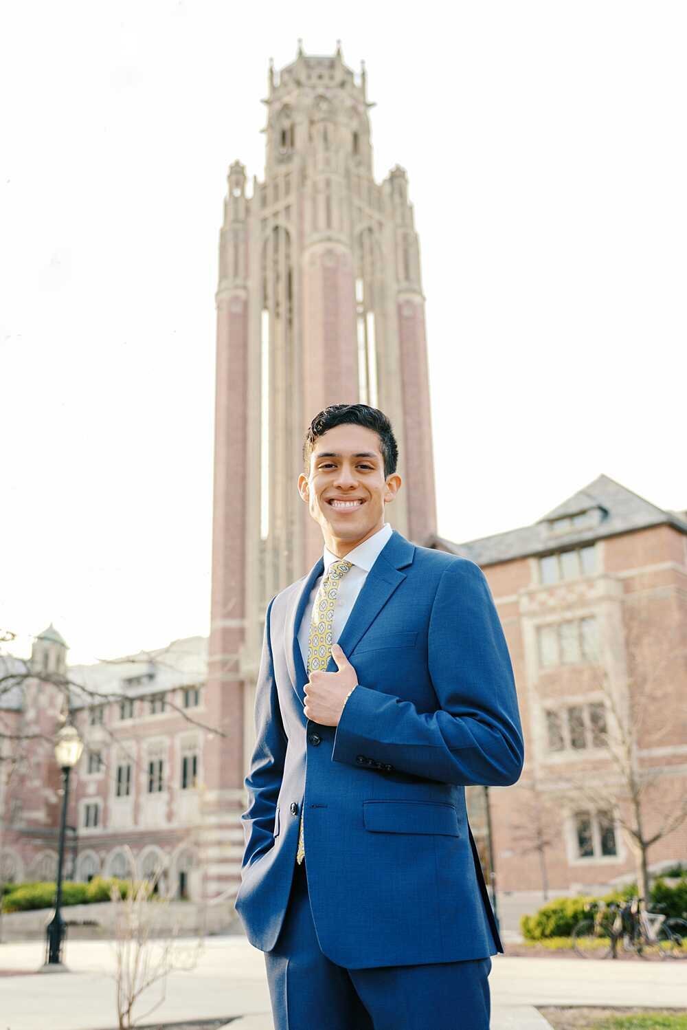 graduating Senior guy wearing a blue suit on his university campus