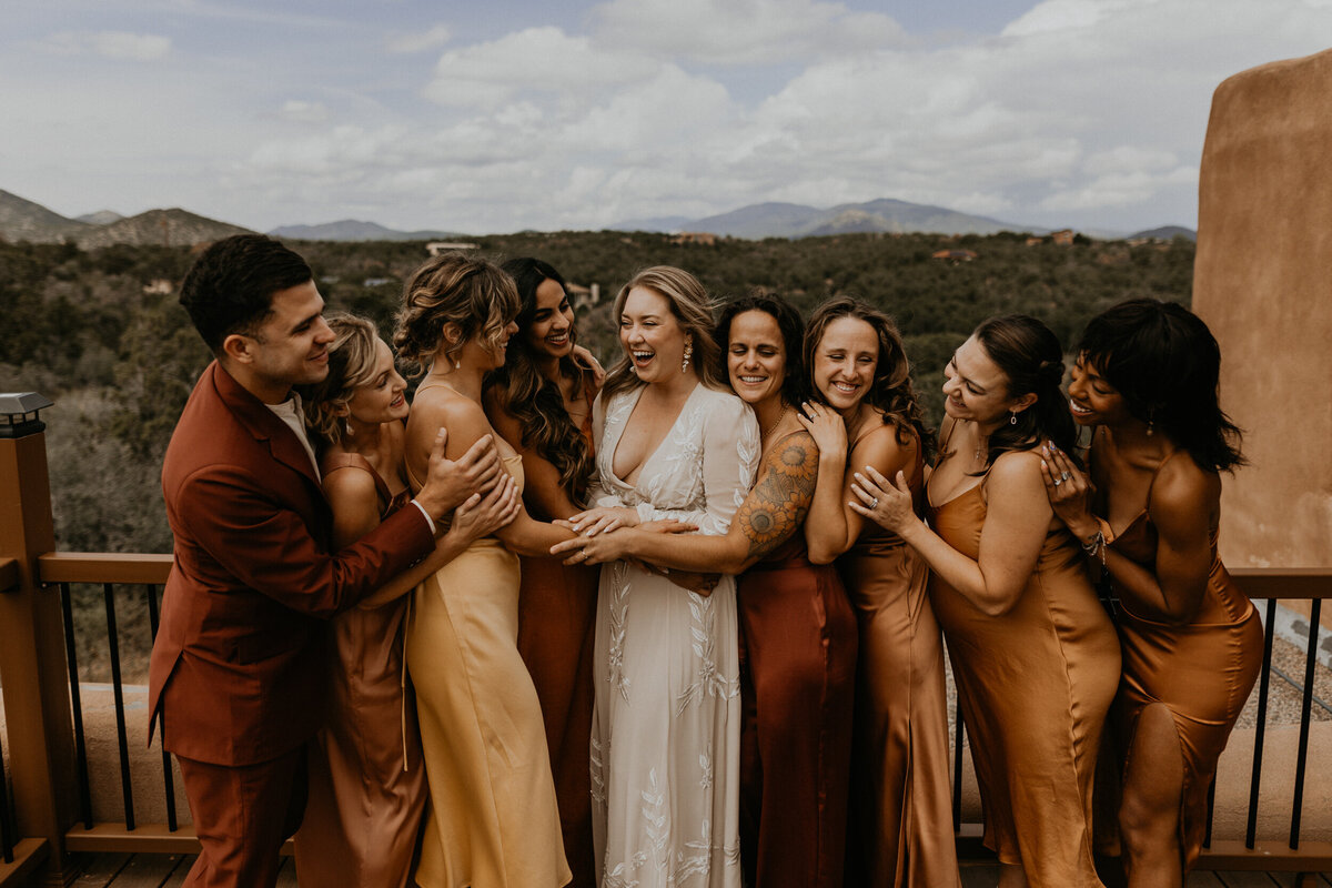 bridal party standing and laughing together
