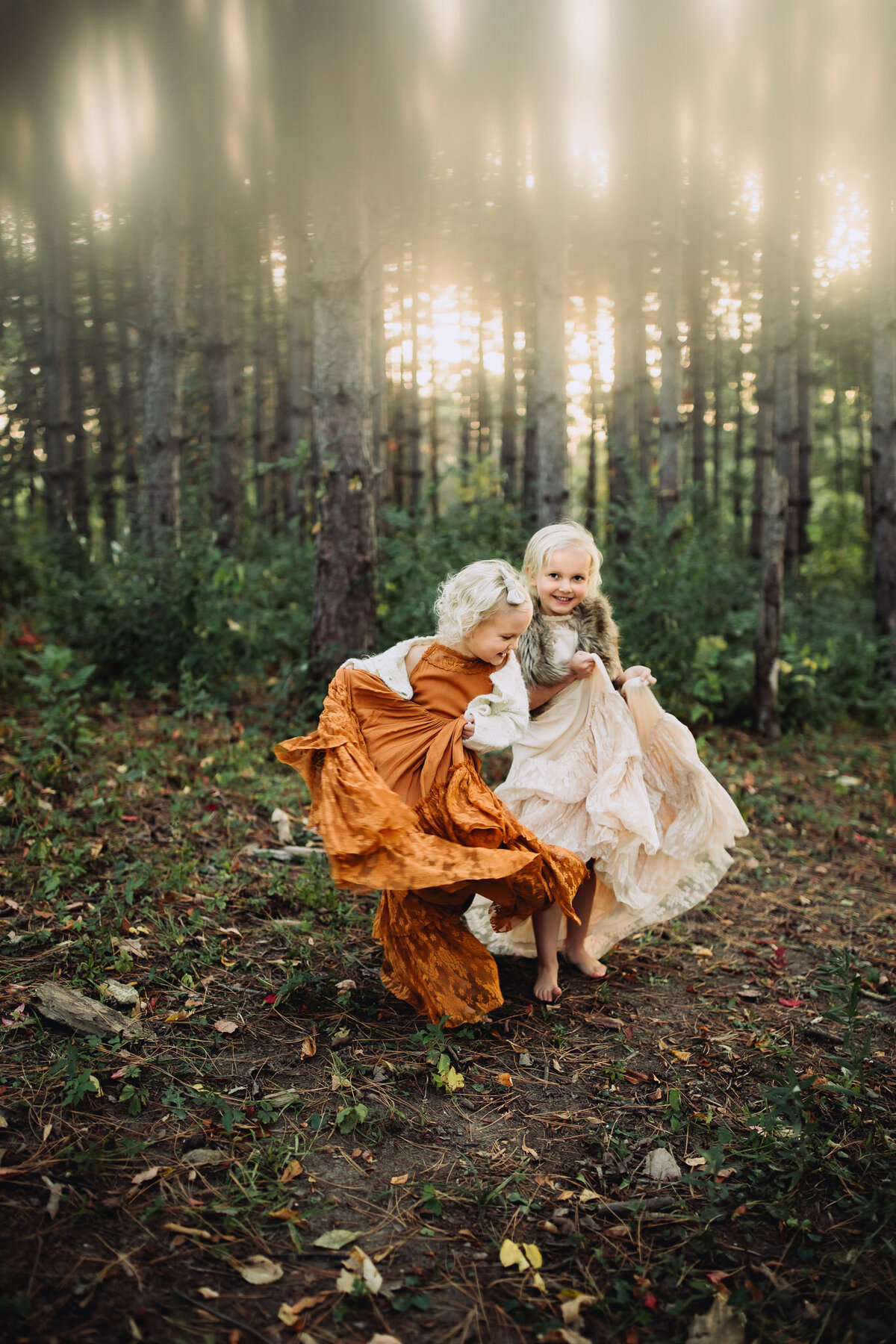 sisters dancing with boho dresses in the woods