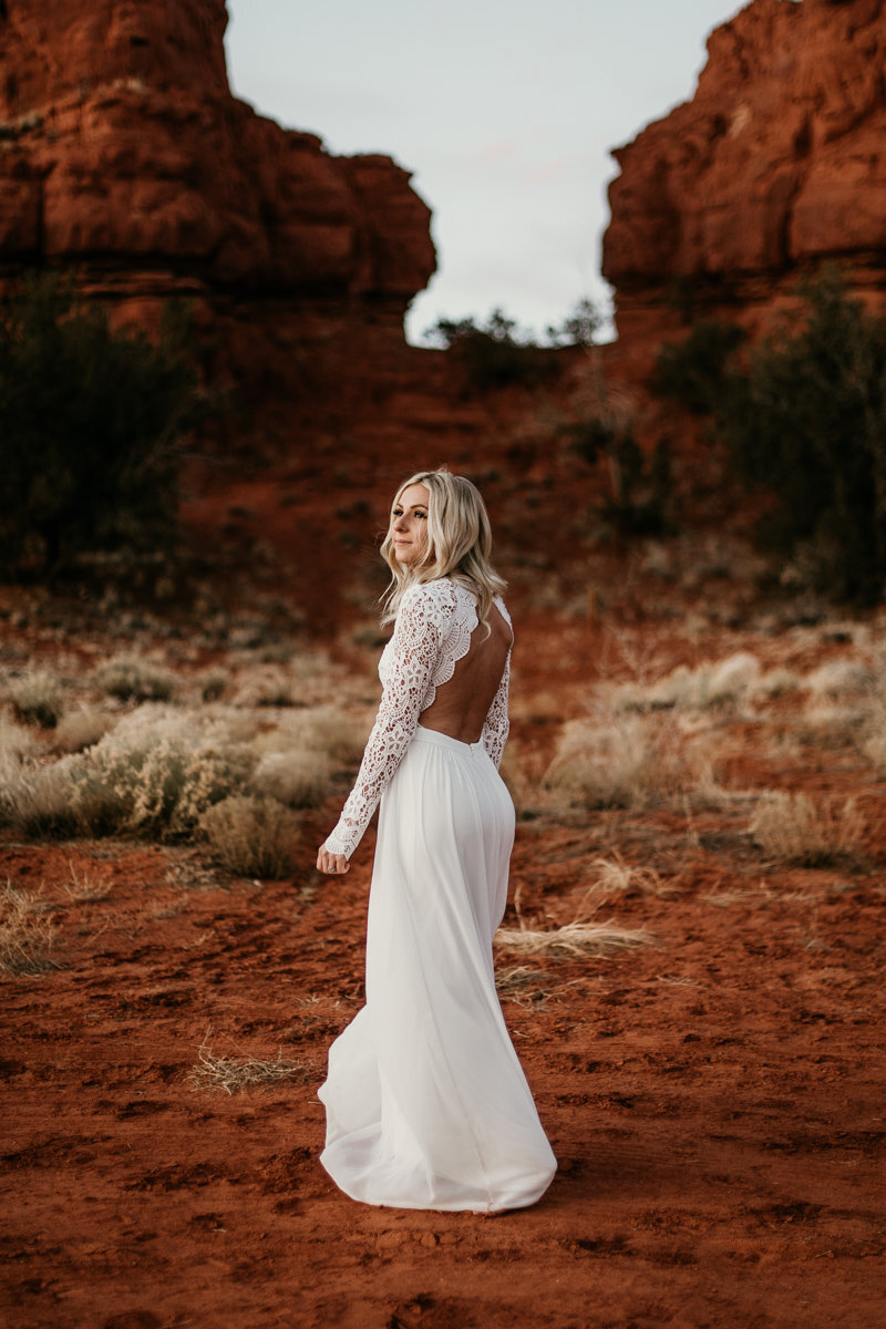 bride spinning in dress in front of red rocks
