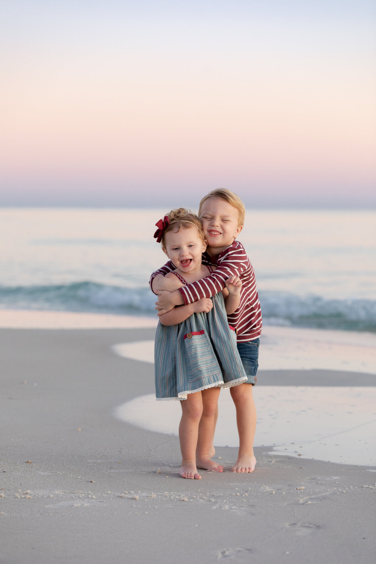 Two siblings hugging and smiling