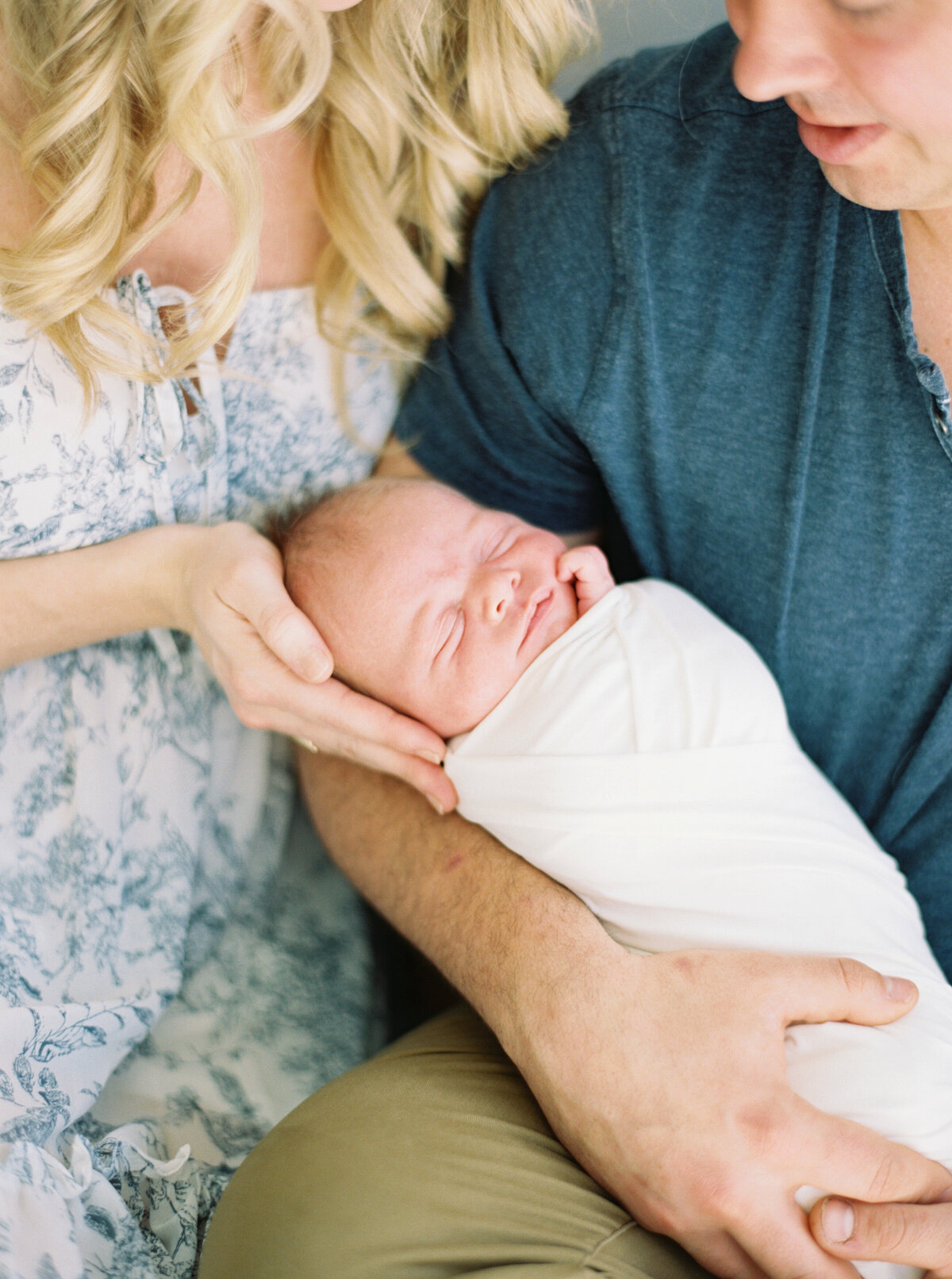 couple in light blue outfits holding newborn baby taken by photographer milwaukee wi Talia Laird Photography