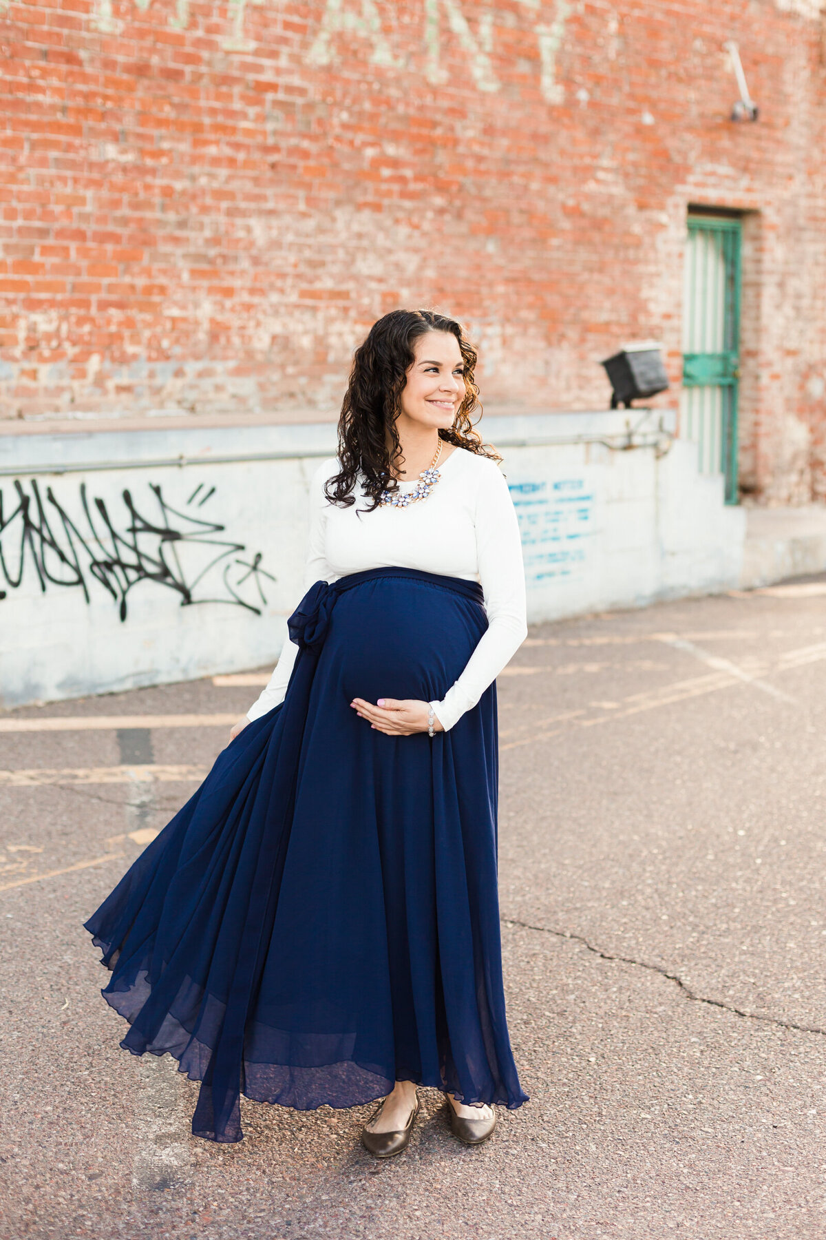 pregnant woman holding baby bump for maternity photography session