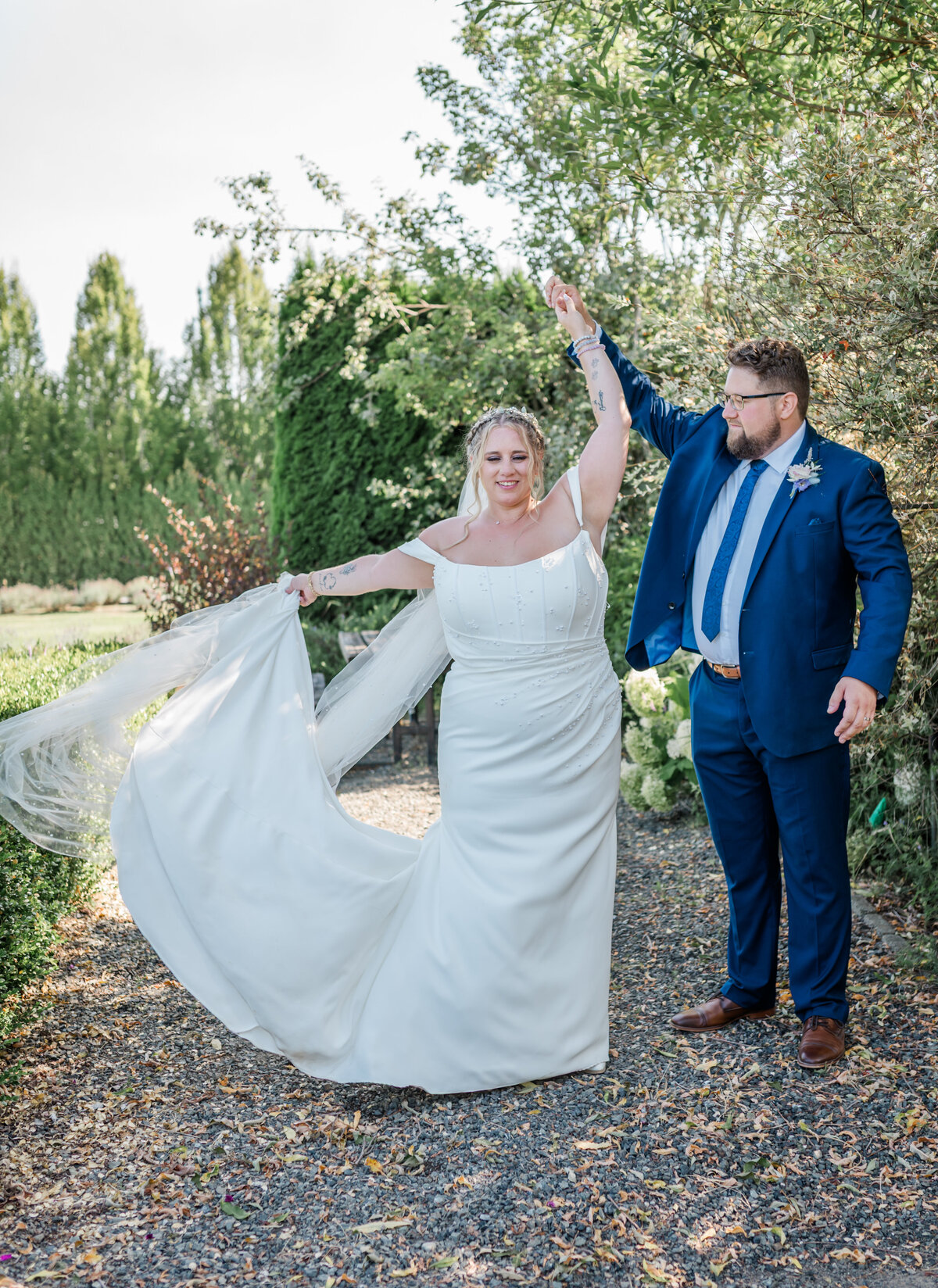 Groom spinning the bride around and looking at her. Greenery in the back round at a lavender farm in Langley BC.