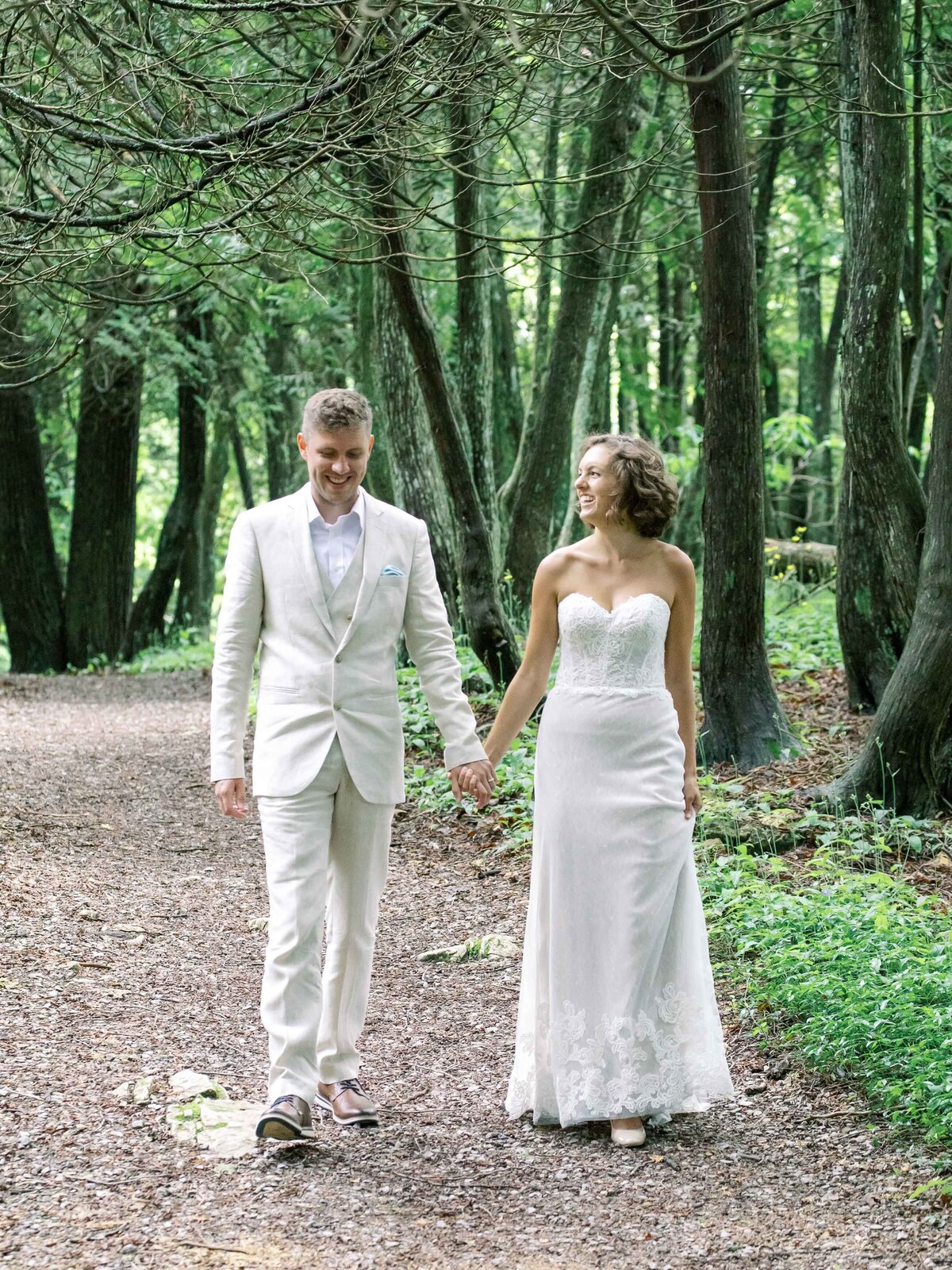 Bride and Groom walking in woods on Mackinac