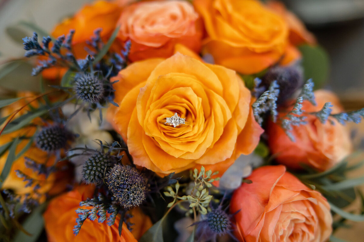 ring detail in orange rose petals at Hayes Hollow Hidden Falls wedding  in Spring Branch Texas