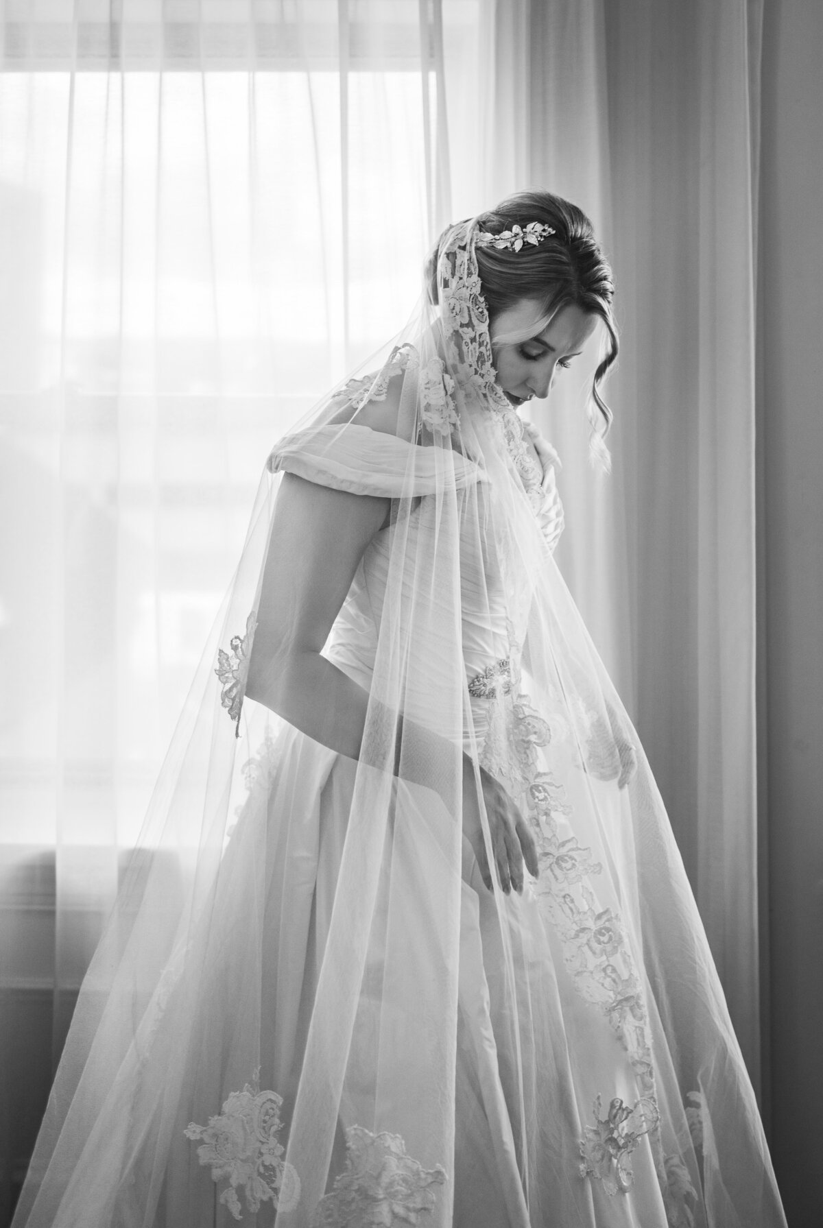black and white backlit portrait of bride in gown