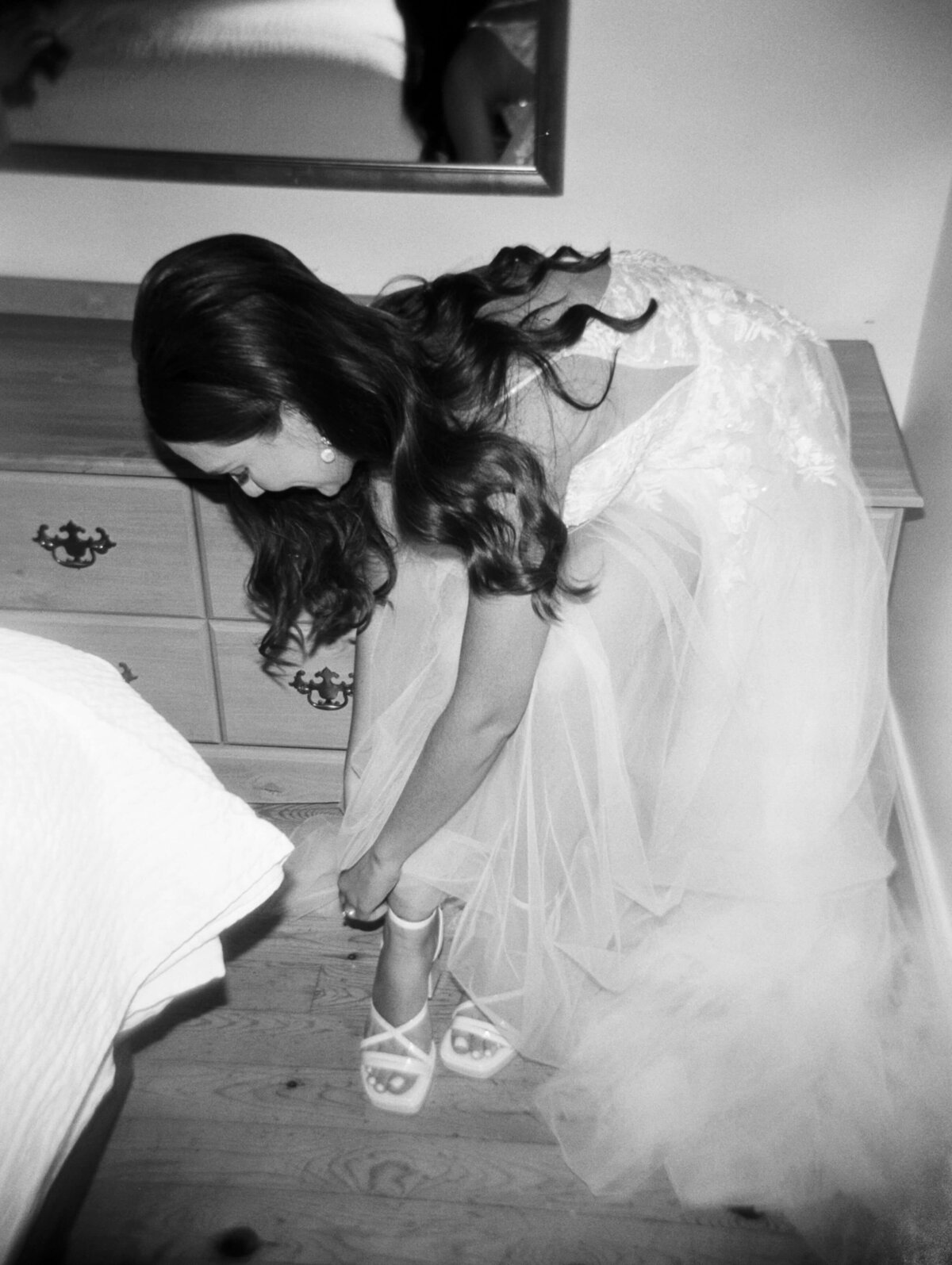 Bride putting shoes on for wedding at Oak Island Resort, Nova Scotia