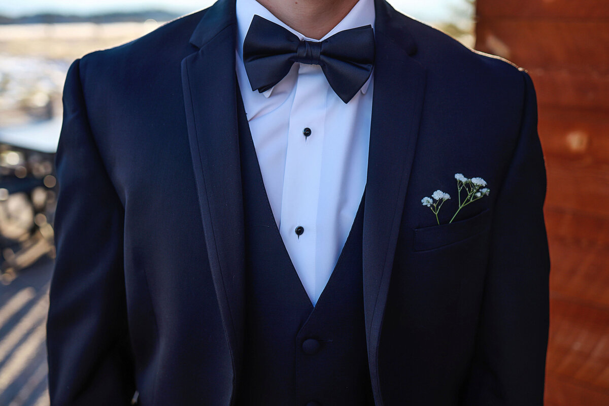 Close up photo of a groom wearing his suit and bowtie, ready to get married,