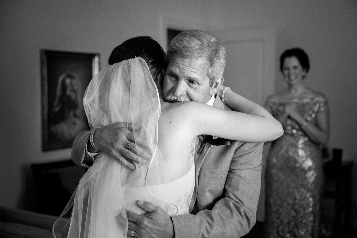An emotional black and white moment as the father of the bride gives his daughter a loving hug