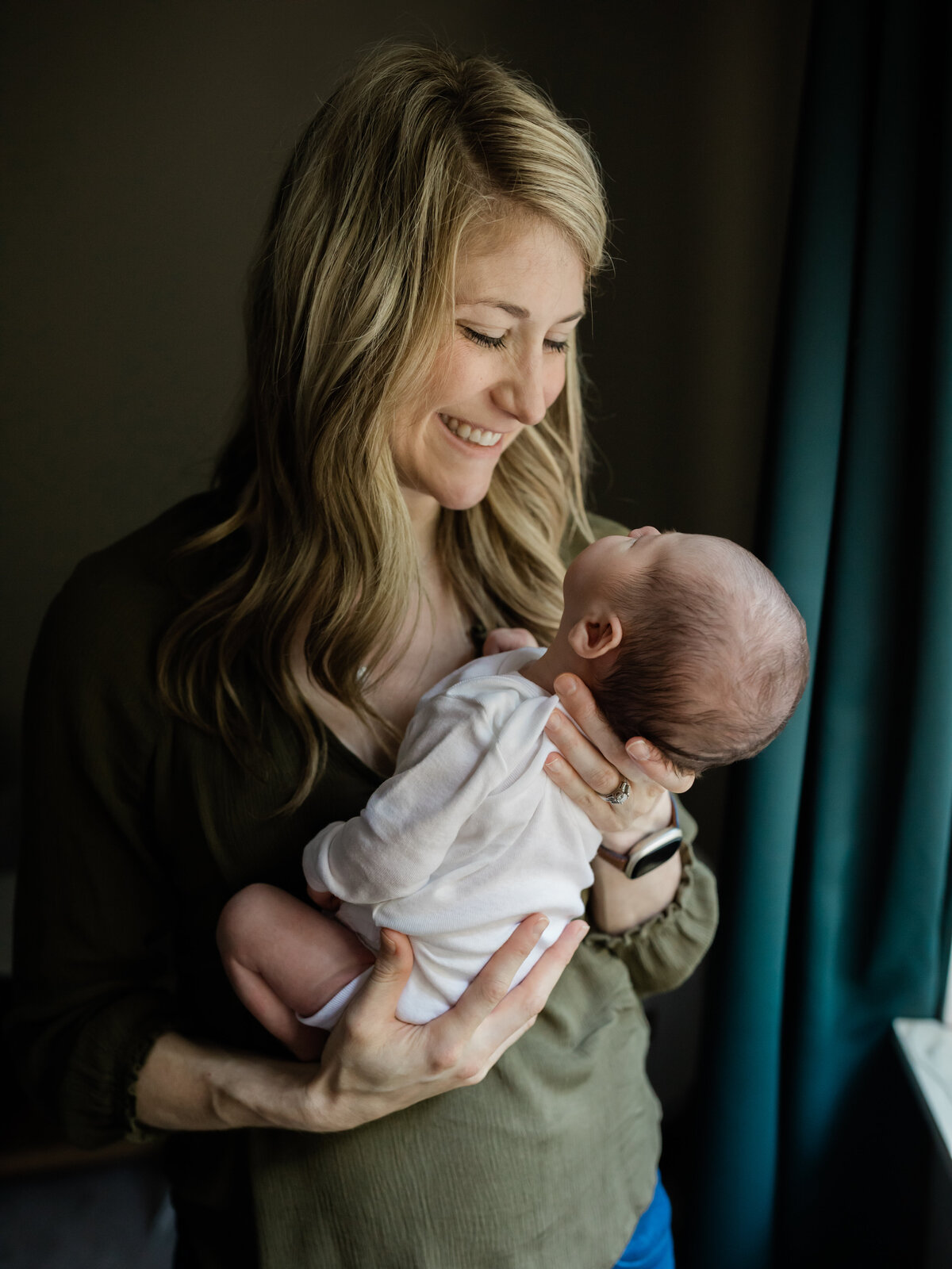 mom holding newborn baby boy in nursery cleveland newborn photographer