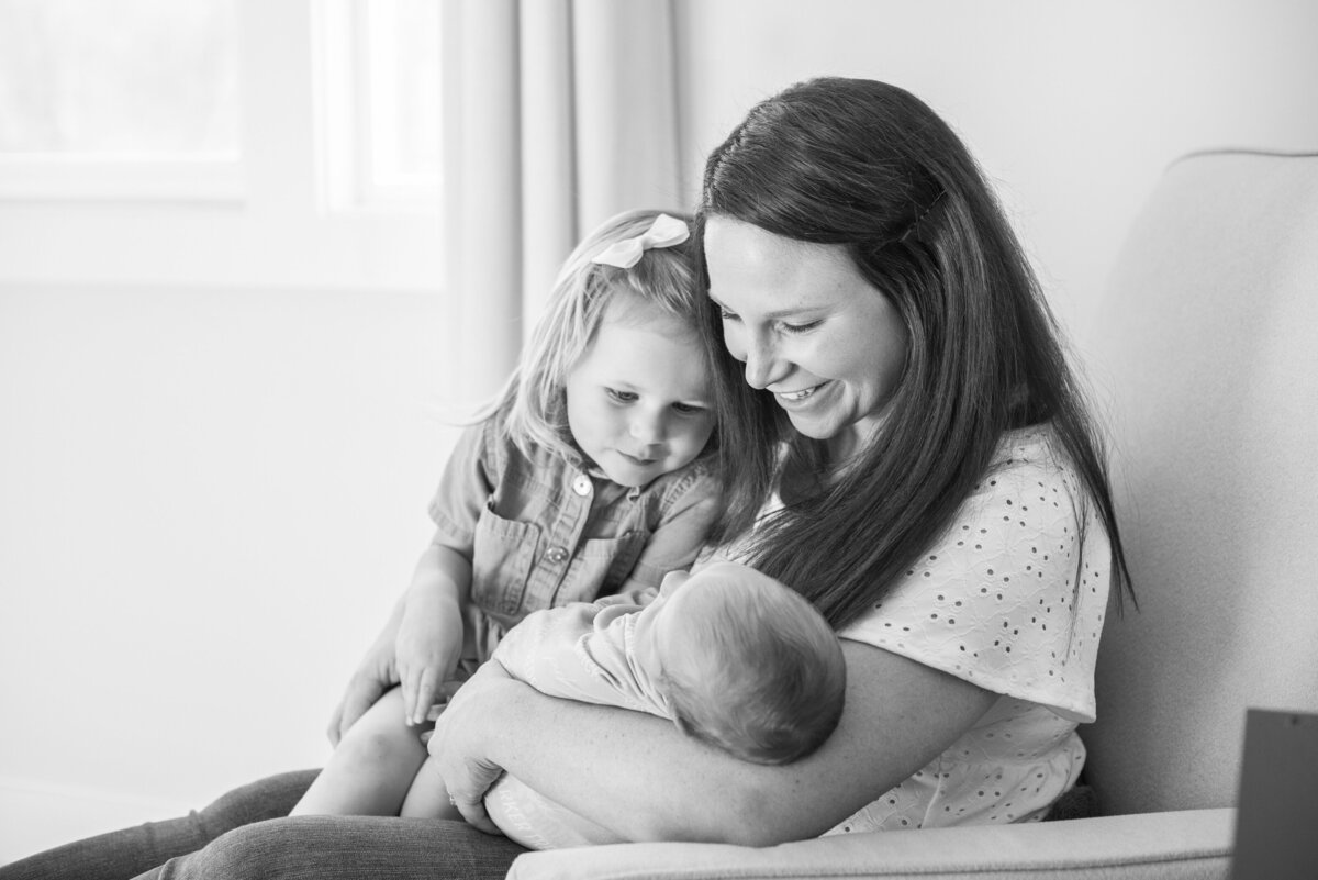 Mom and sister holding baby at home newborn photography Asheville NC