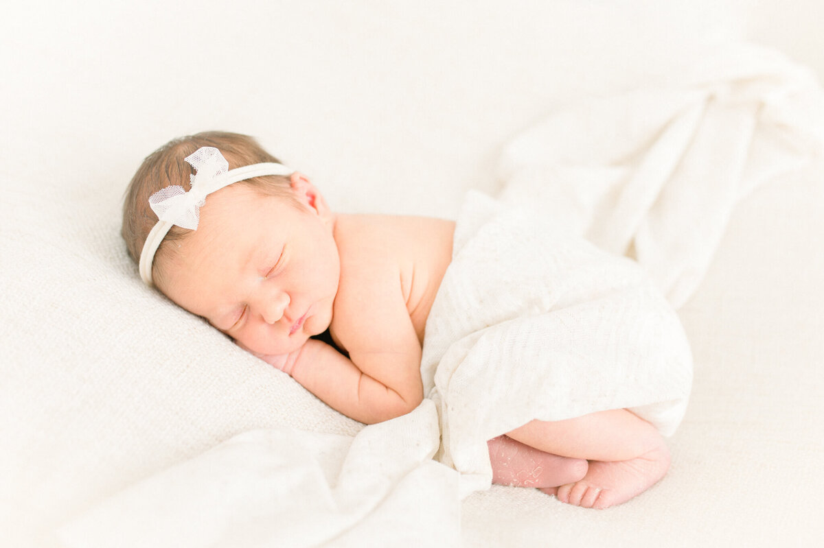 Baby sleeping with swaddle over bum. Captured by Niagara newborn photographer