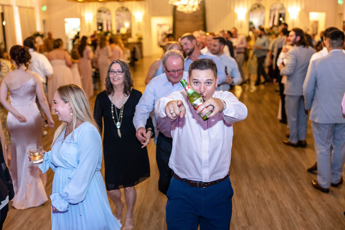 guest holding beer points at Fort Worth wedding photographer