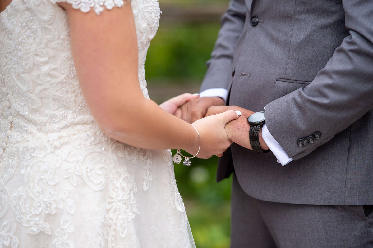 a closeup photo of a bride and groom holding hands during their Ottawa wedding ceremony at Strathmere