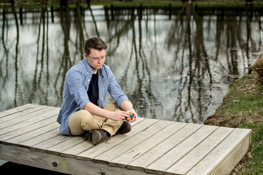 senior boy on dock with rubiks cube