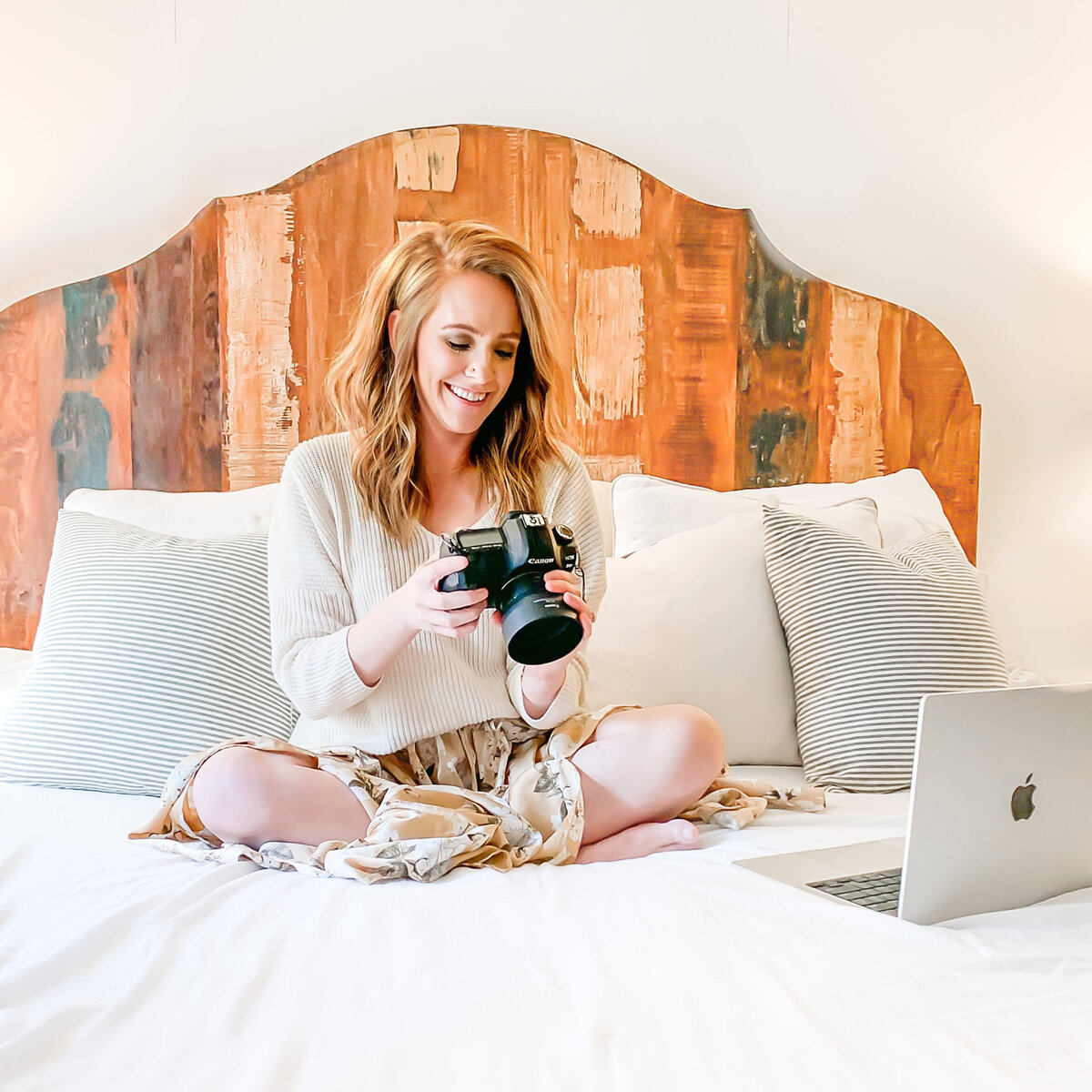 Photographer sitting on bed holding camera