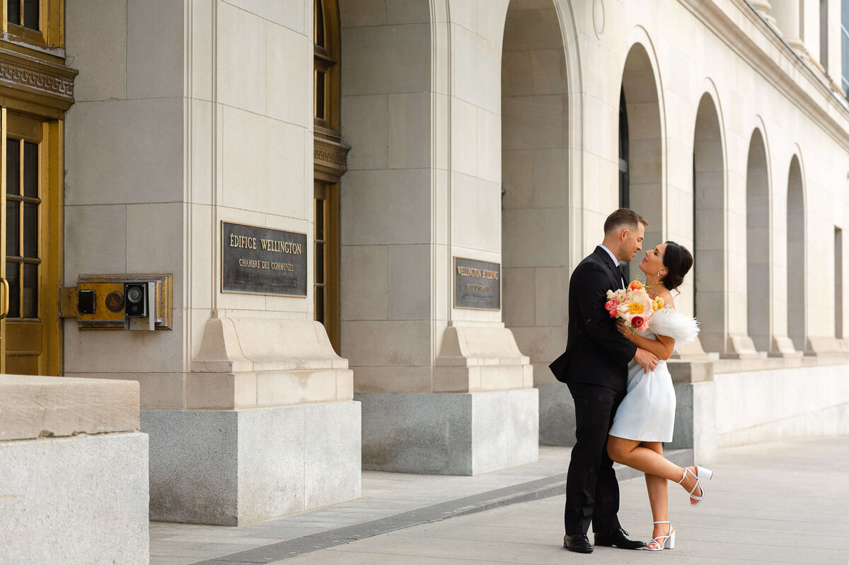 Ottawa wedding photography showing a bride and groom kissing outside the Chateau Laurier hotel