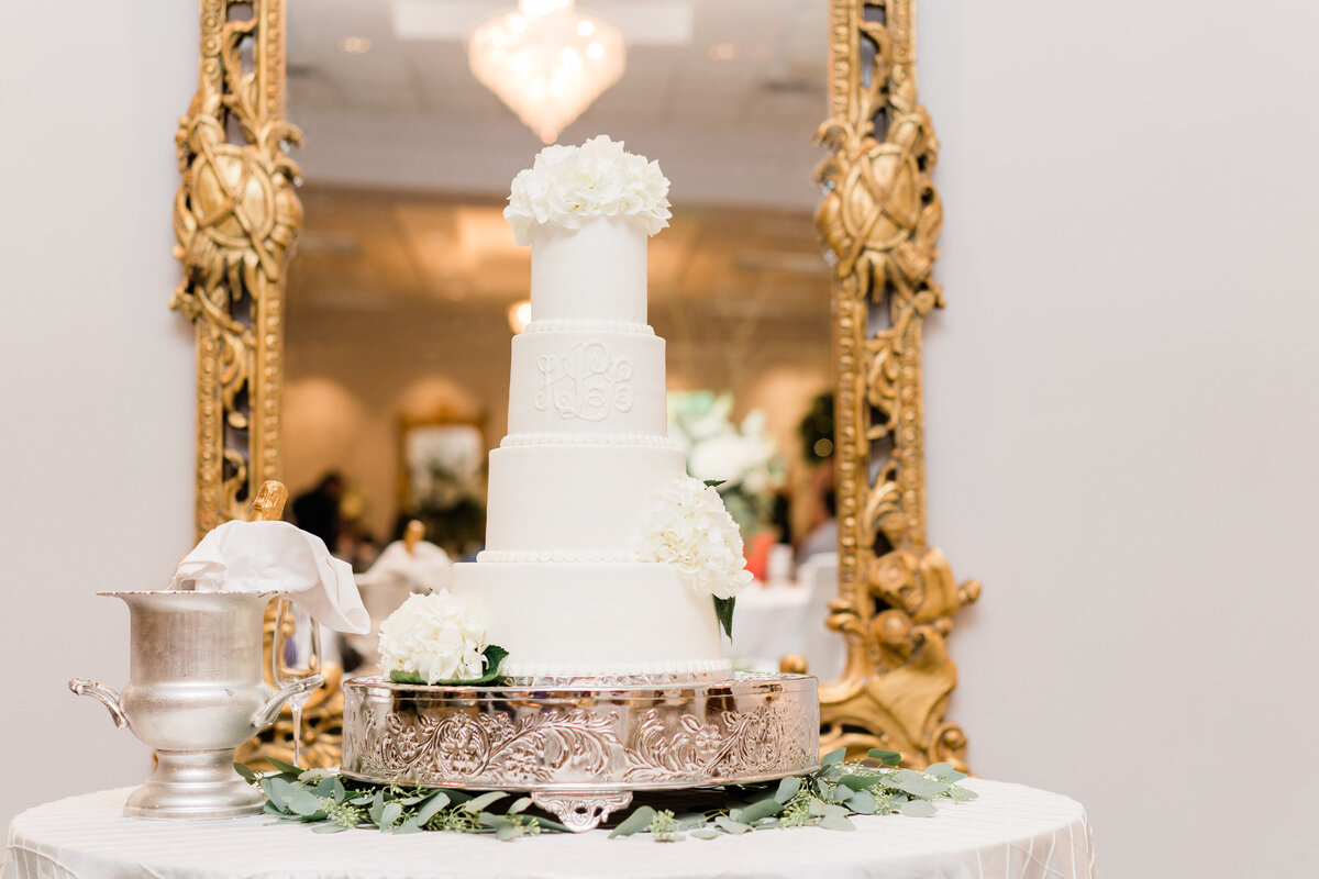 White wedding cake against mirror with gold frame