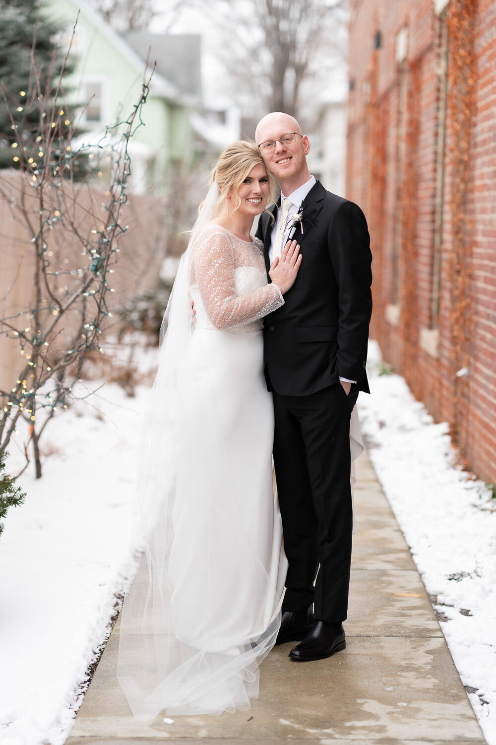 Bride and groom smile in the snow in Saint Paul, Minnesota.