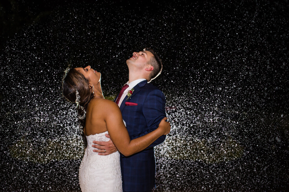 bride and groom dancing in the rain on their wedding day