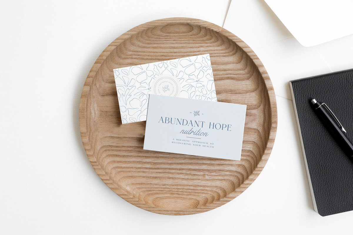 Business cards with primary logo and pattern sitting in a wood bowl