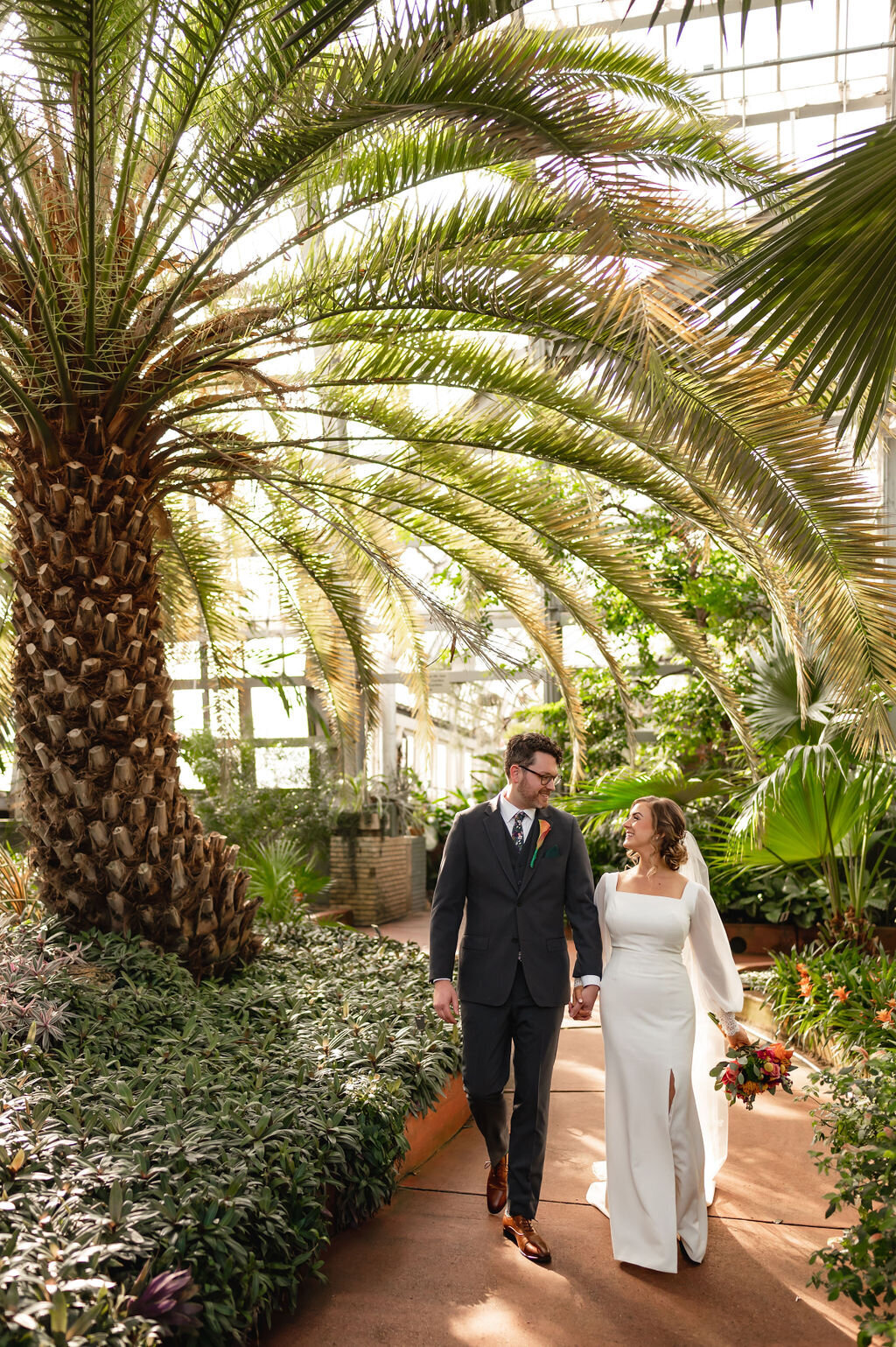Couple walk by palm trees in Garfield Park Conservatory