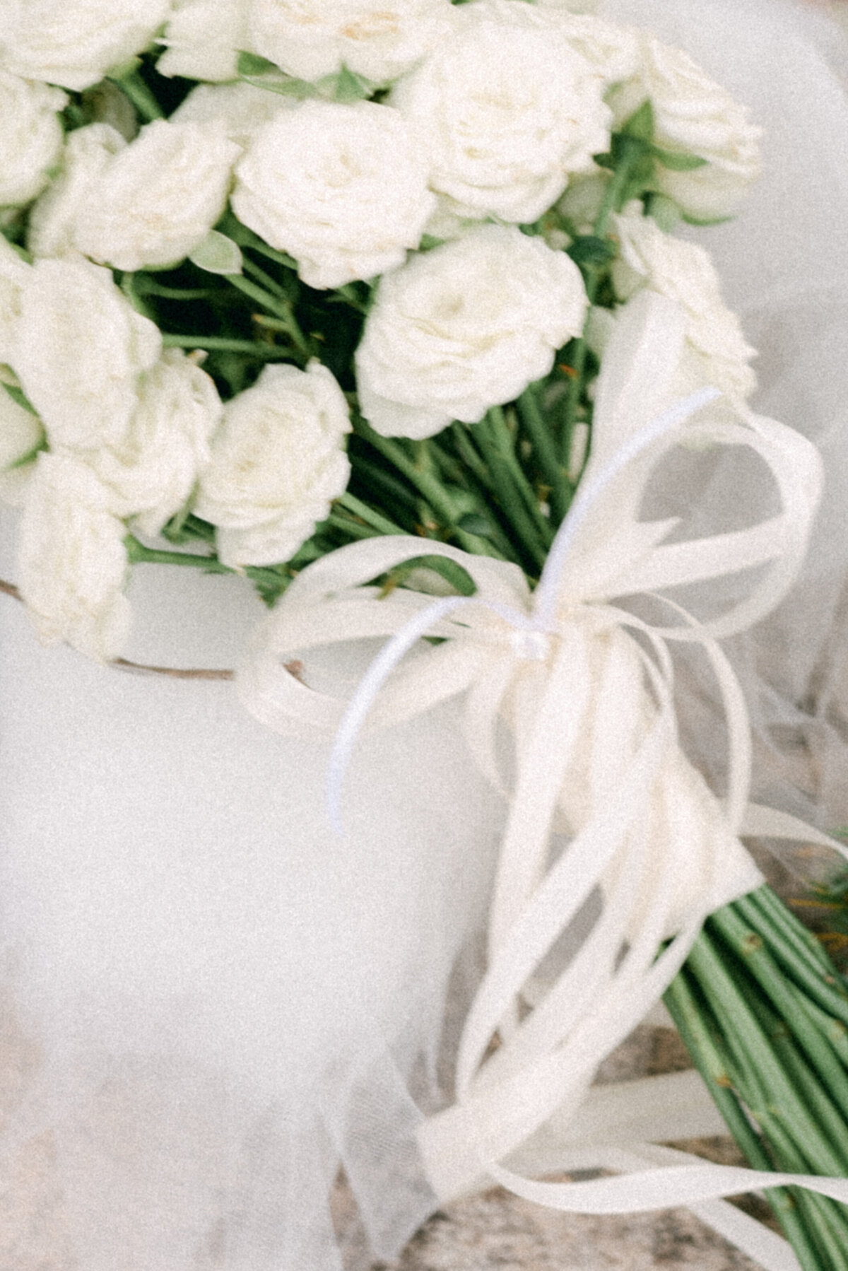 A detail image of a wedding bouquet of white roses and white laces photographed by wedding photographer Hannika Gabrielsson.