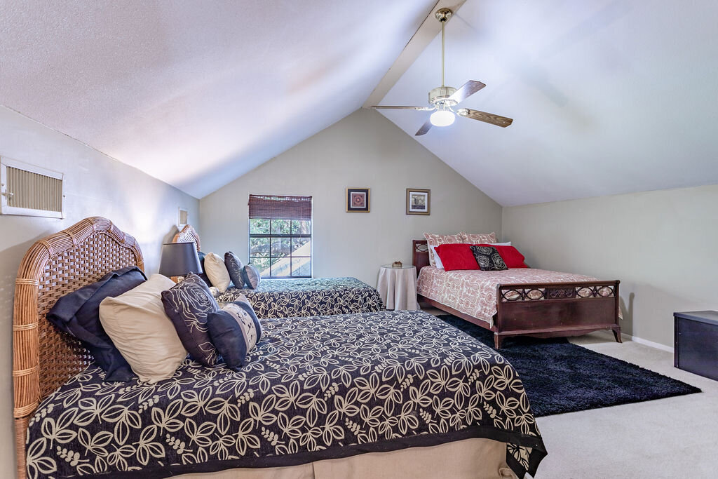 Spacious bedroom with three beds in this 5-bedroom, 4-bathroom vacation rental house for 16+ guests with pool, free wifi, guesthouse and game room just 20 minutes away from downtown Waco, TX.