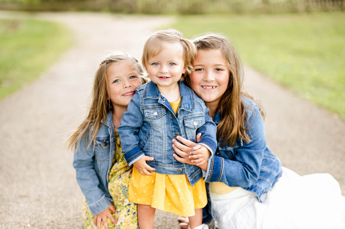 Three young girls in matching jean jackets at family photo session with Everything is Grace.
