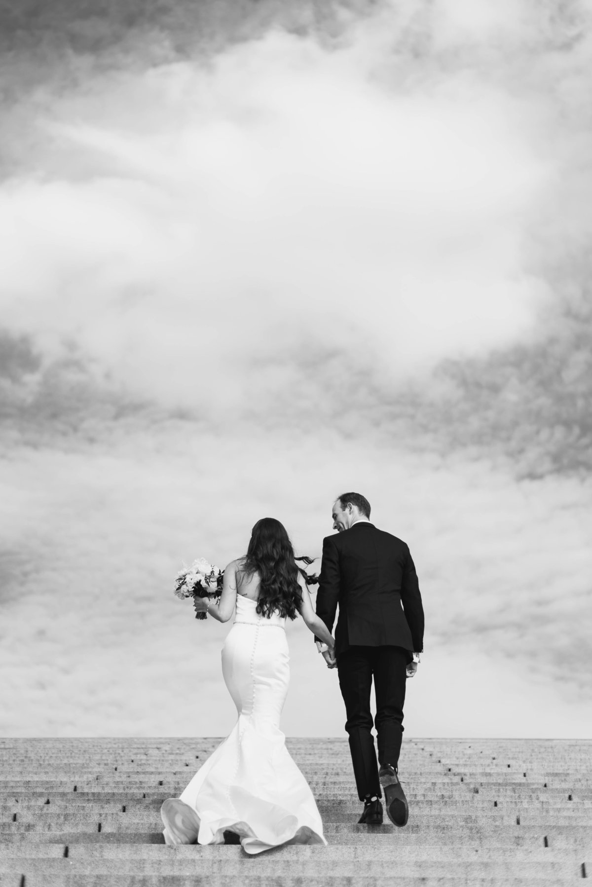 black and white image of bride and groom climbing stairs on Washington DC's national mall