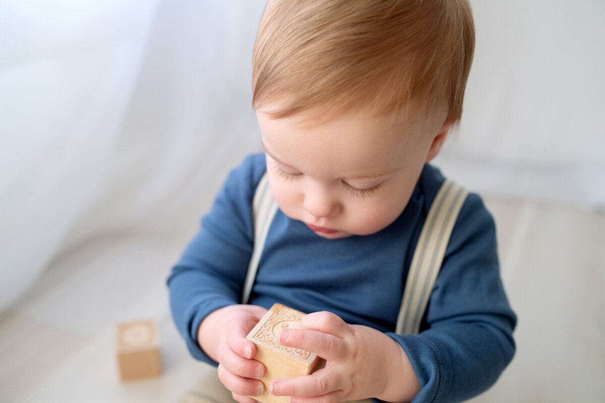 Family session of little boy holding a toy block