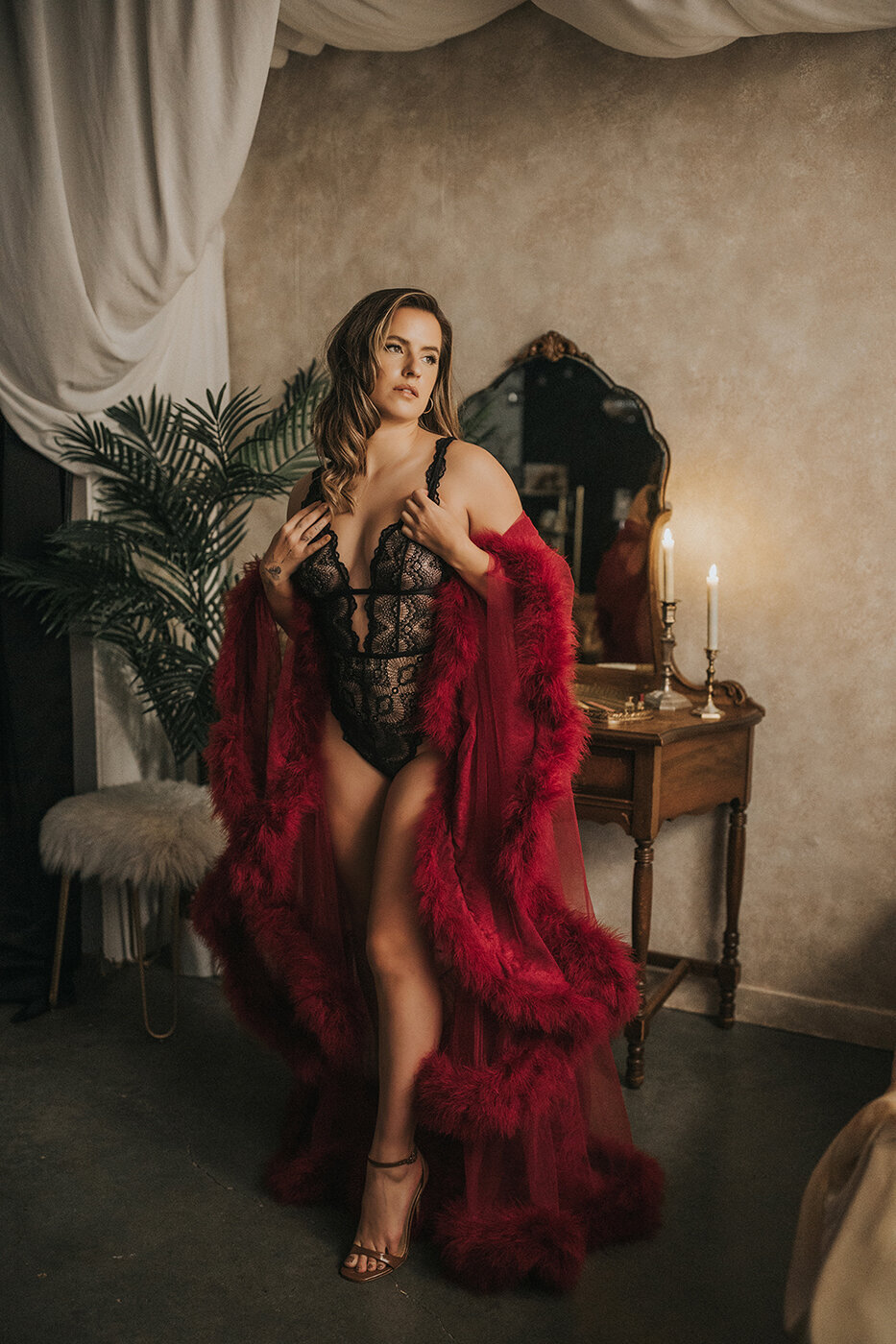 boudoir photography client standing in a red feather robe