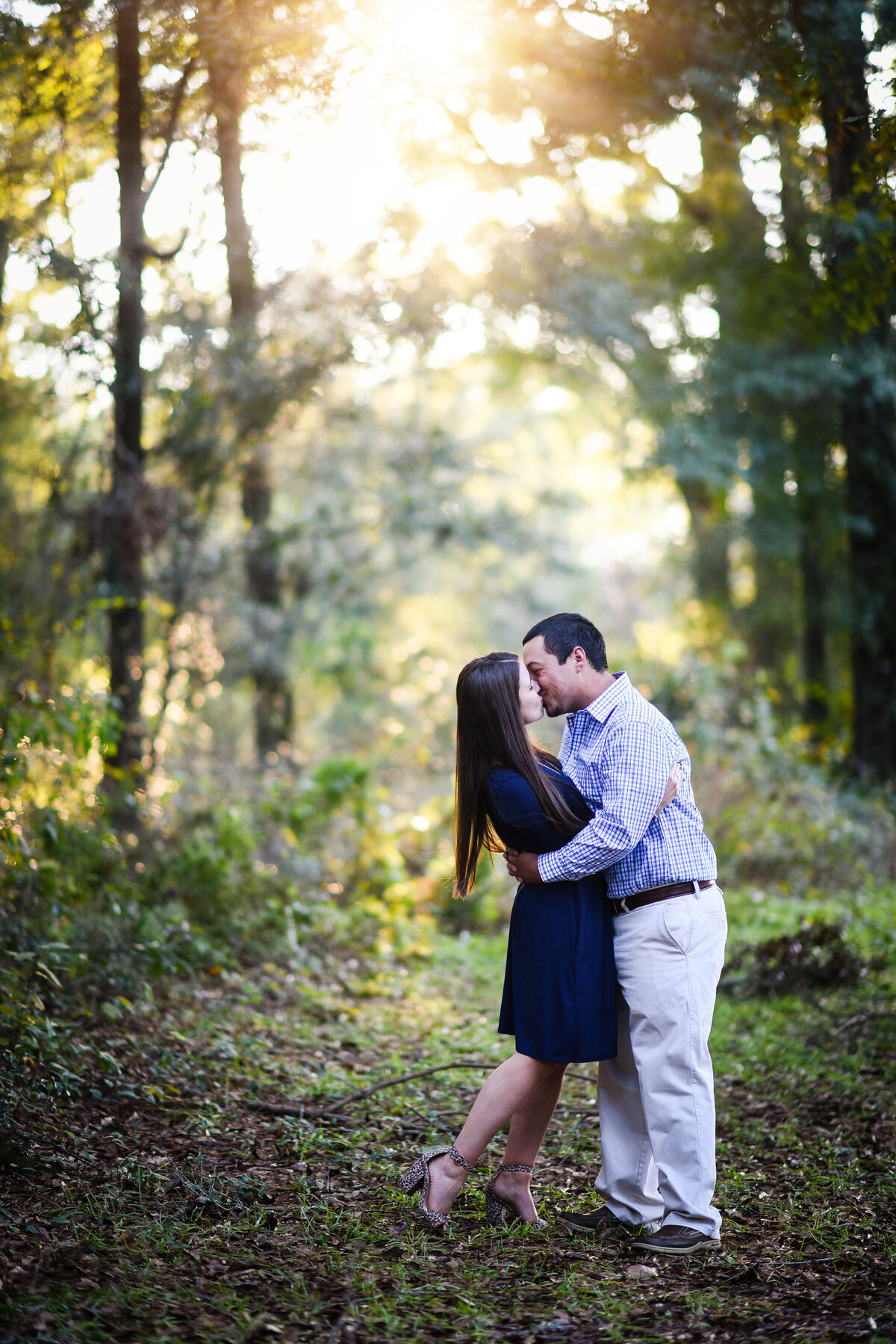 Beautiful Mississippi Engagement Photography: couple kisses in a forest at sunset
