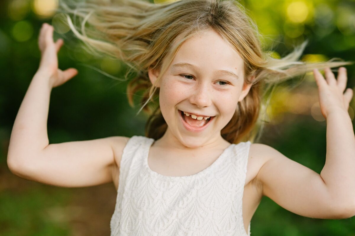 girl flips her hair and laughs during a mini photo session