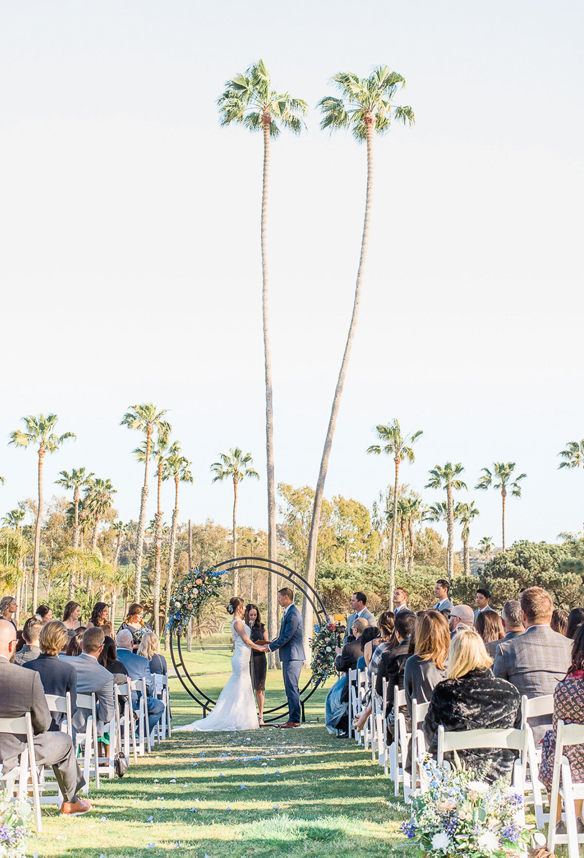 Wedding Photographer, a bride and groom exchange vows  outside  before family and friends