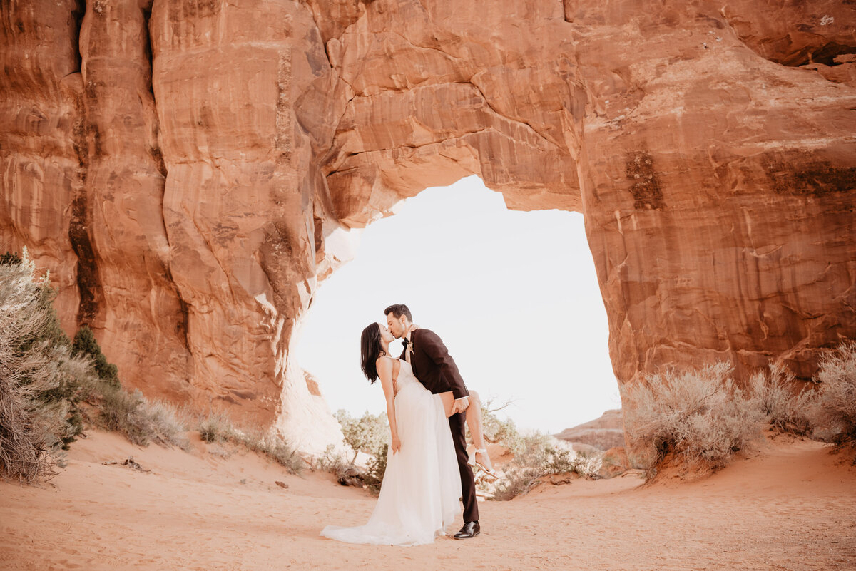 Utah elopement photographer captures groom lifting woman's leg