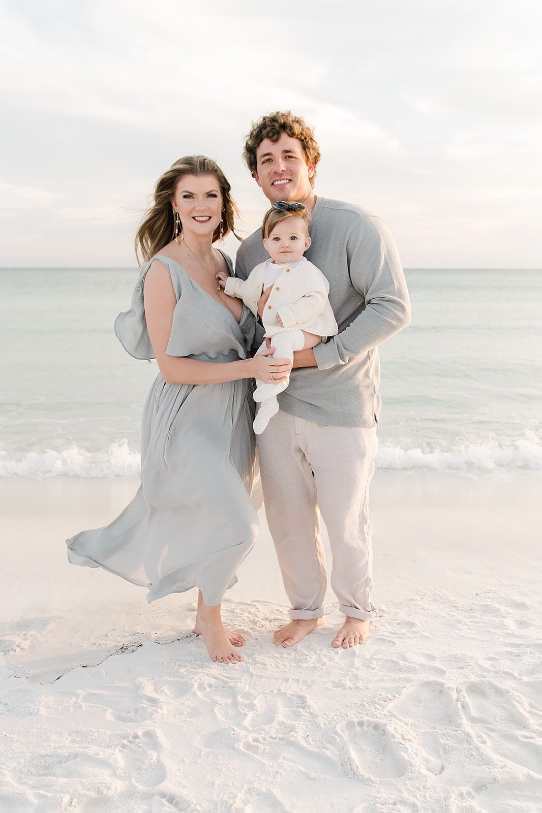a family posing in front of the gulf in destin florida during photo session