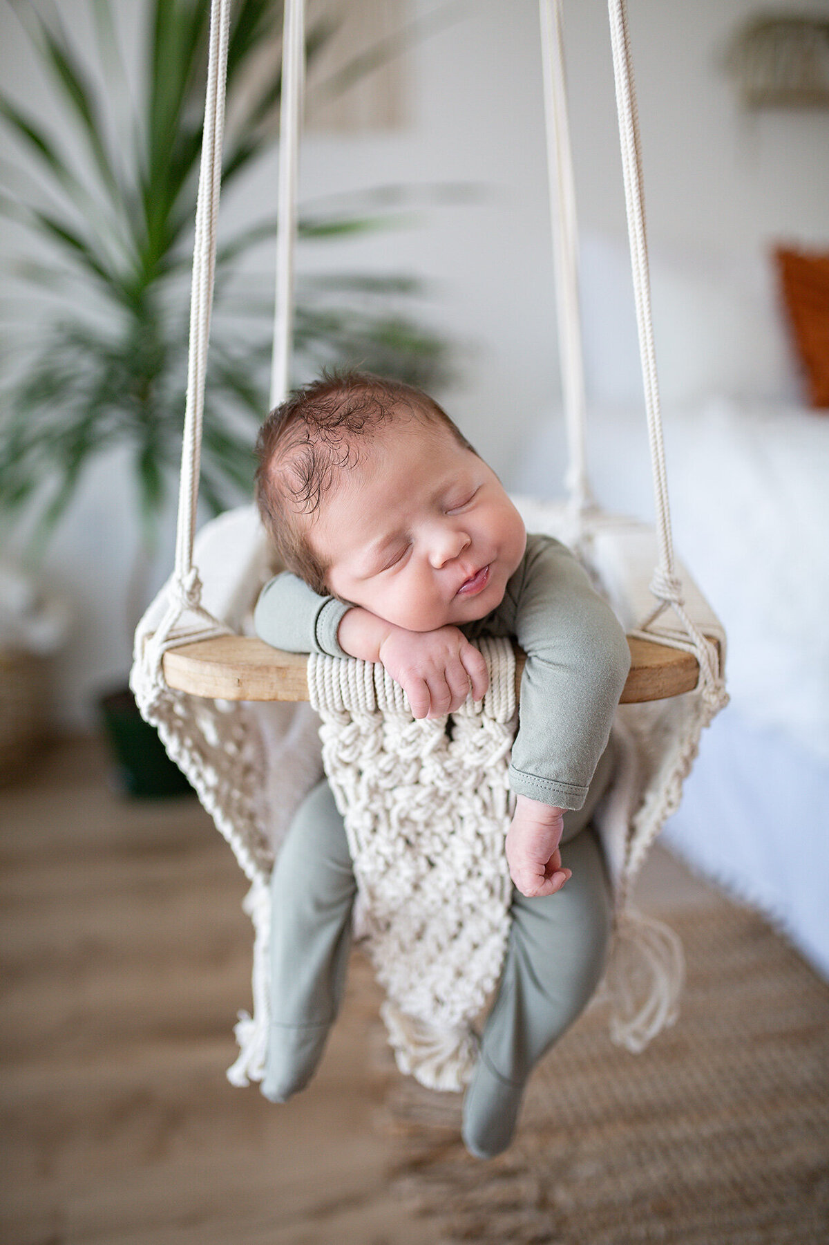 newborn posed in boho swing